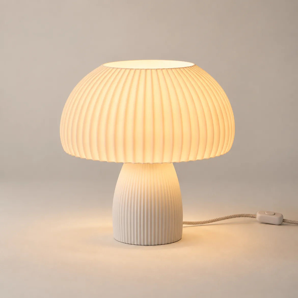 Abajur cogumelo Lucca aceso, cúpula canelada branco cru com luz quente